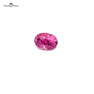Close-up of a faceted pink sapphire, showcasing its brilliance on a white turntable.
