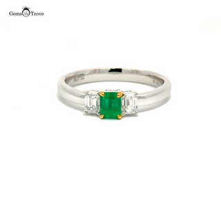 Elegant emerald wedding band showcasing a vibrant Colombian emerald and two diamonds, crafted in luxurious 18K gold