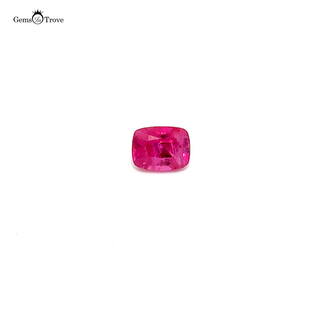 Close-up of a faceted pinkish ruby, highlighting its vibrant color on a white turntable.