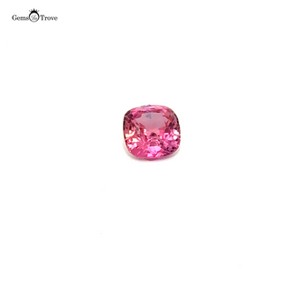 Cushion-cut padparadscha sparkles against white background