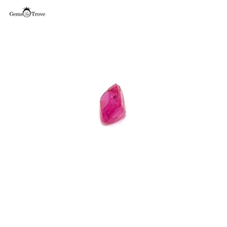 A pinkish-red rectangular ruby gemstone displayed on a white turntable.