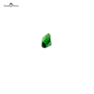 Close-up of a faceted tsavorite gemstone, showcasing its vibrant green hues on a white turntable.
