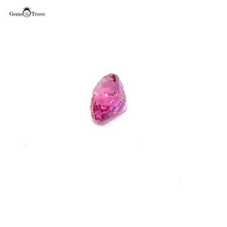 A soft pink oval-cut sapphire gemstone displayed on a white turntable.