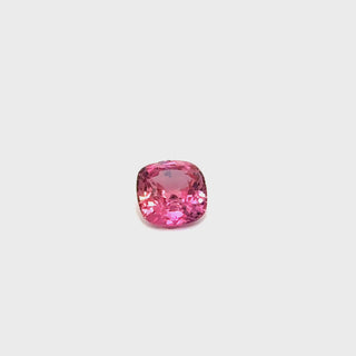 A rotating padparadscha sapphire gemstone, displaying its vibrant hues under professional lighting.