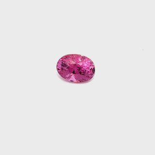 A rotating 1.92ct pink sapphire gemstone on a white turntable, showcasing its sparkle.