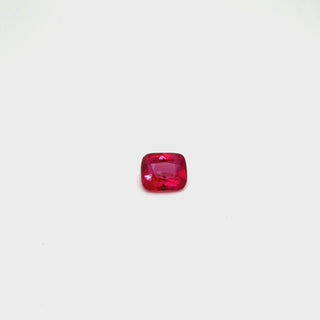 A rotating 1.02ct ruby gemstone on a white turntable, showcasing its brilliance from every angle.