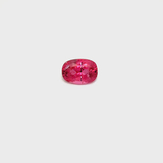 A rotating 2.05ct pink spinel gemstone on a white turntable, showcasing its soft hue.