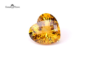 Heart-shaped amber citrine gem with reflective surfaces, warm sparkle on white.
