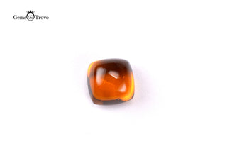 Oval citrine cabochon, translucent orange-brown hue, close-up on white.