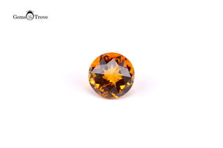 Glossy orange citrine gemstone, sharp facets and vibrant hue on white.