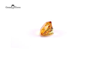 Golden-brown citrine gemstone with radiant cuts on plain white background.