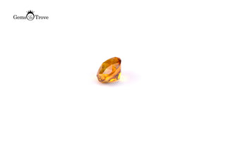 Translucent orange citrine gem with vibrant color, reflective facets on white.
