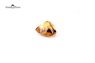 Heart-shaped yellow citrine gem with light-reflecting facets on plain white.