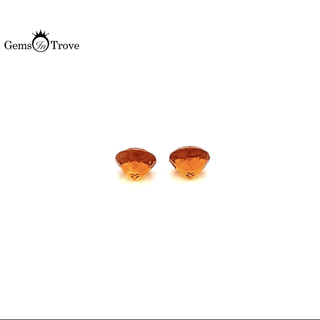 Round orange citrine gemstones, fiery hue, symmetrical on plain white.